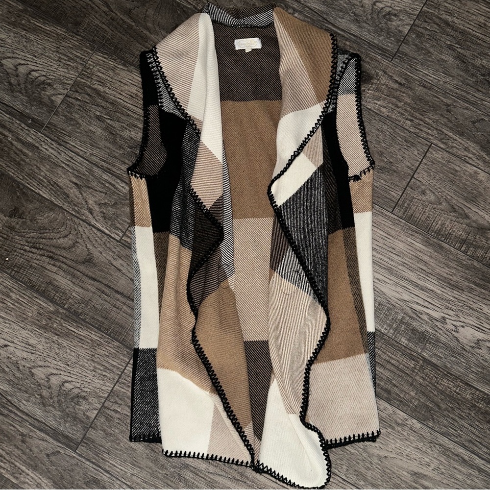 Camel , black and white sweater vest .